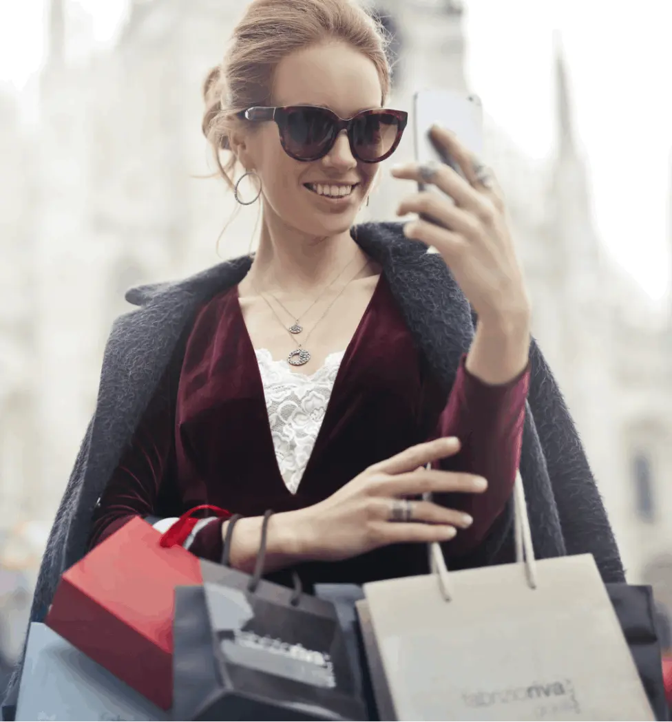 Frau telefoniert mit Smartphone und Shoppingtüten